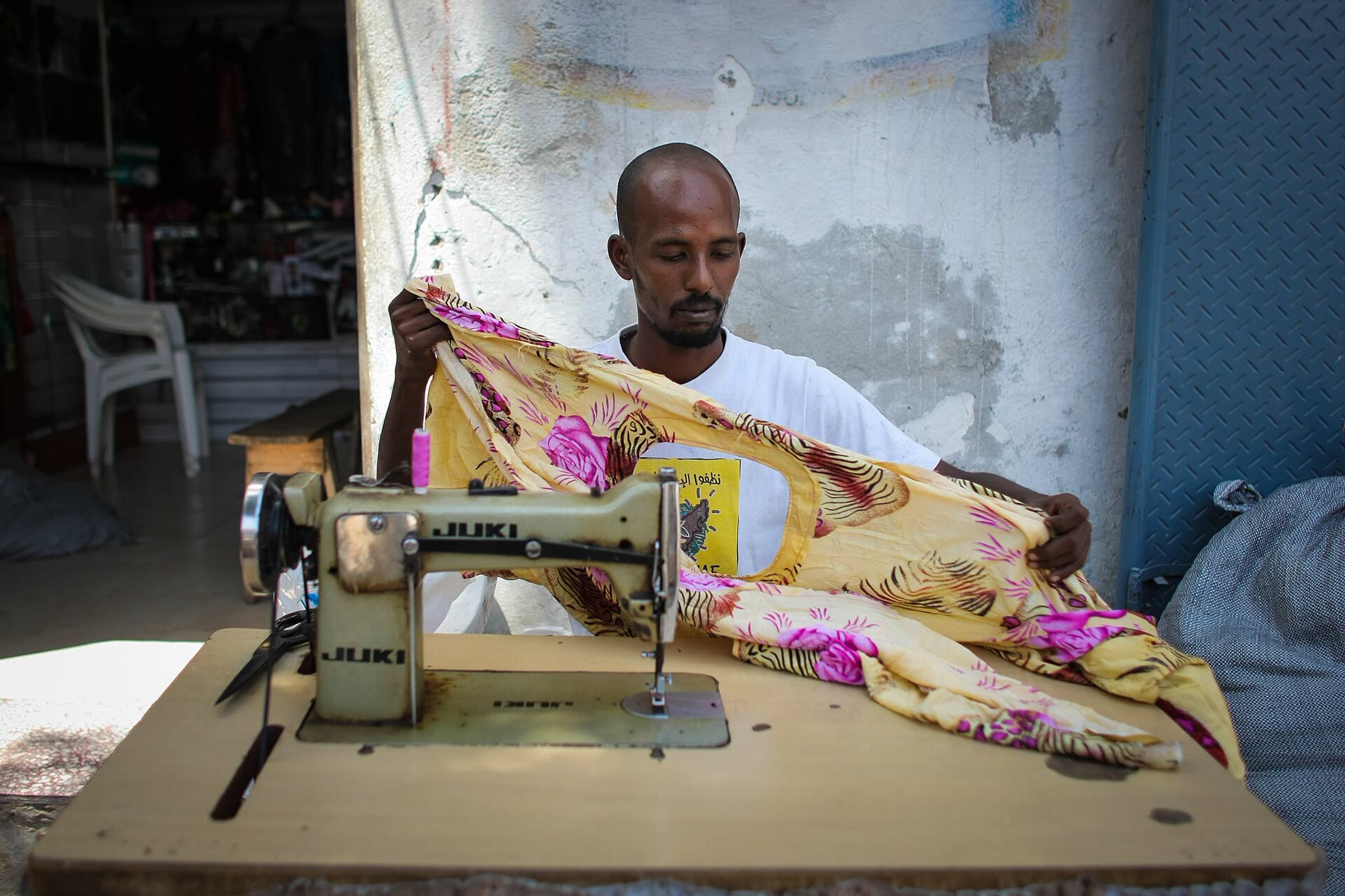 A tailor at a sewing machine in a Mogadishu workshop
