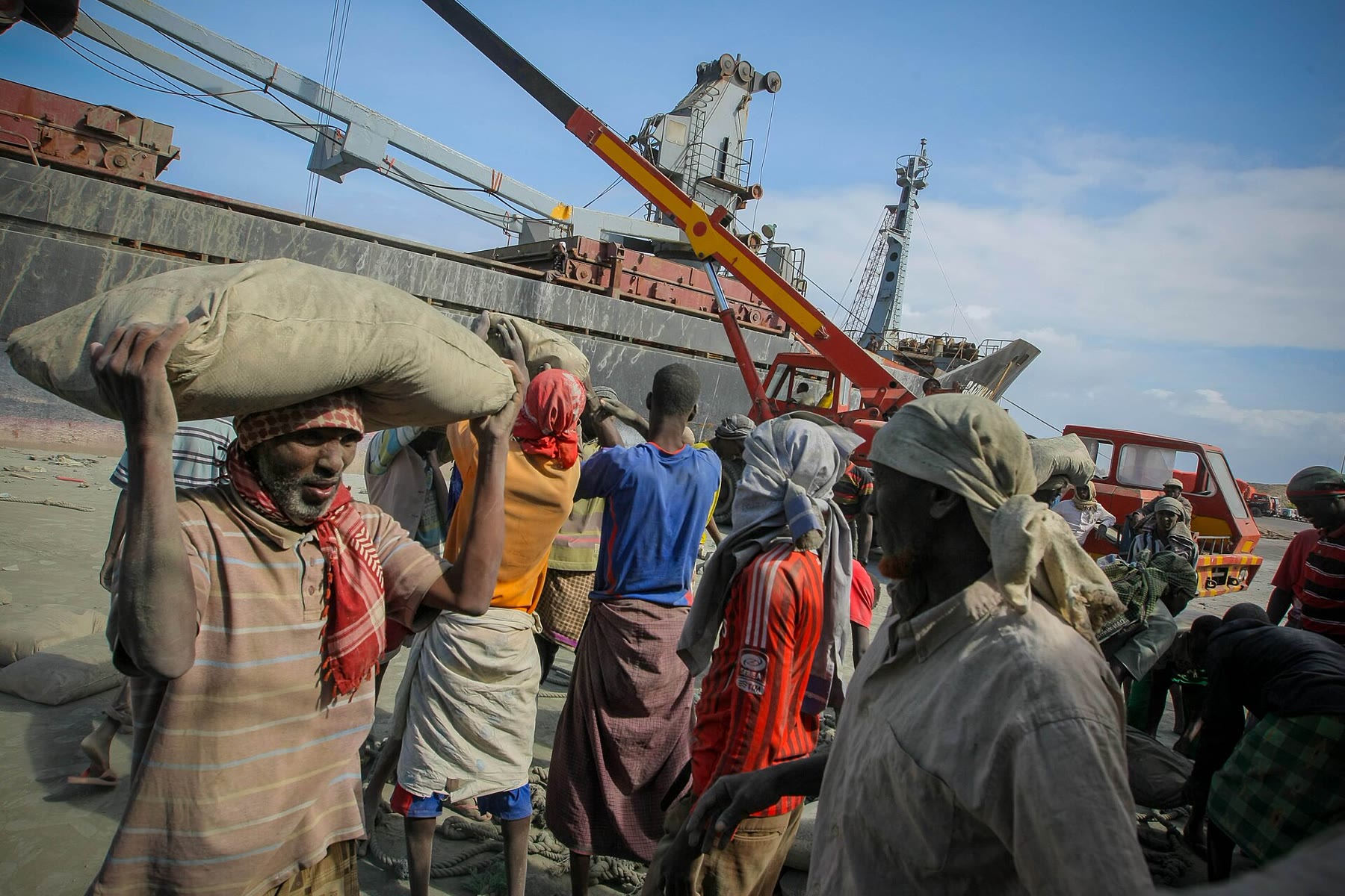 Porters carrying sacks away from a ship in Mogadishu