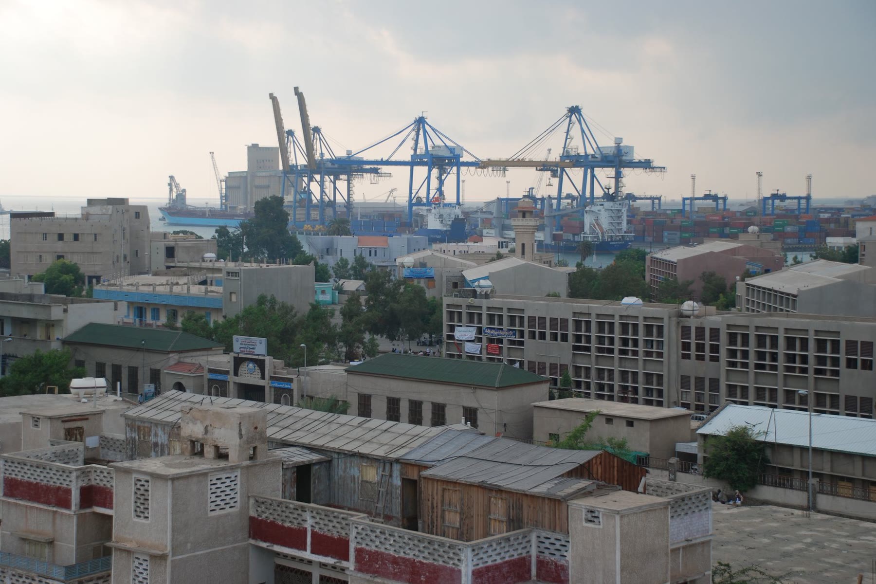 Rooftops in Port Sudan with the harbour cranes behind them